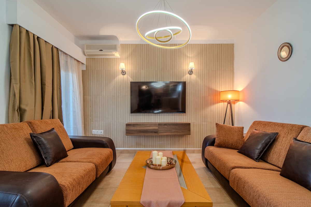 Kiini cha Nyumba ya Ndoto ya Helena – sebule yenye starehe ambapo tani za joto, mwanga maridadi na viti vya kustarehesha vinakualika kupunguza kasi, kupumzika na kufurahia jioni za pamoja baada ya siku kando ya bahari