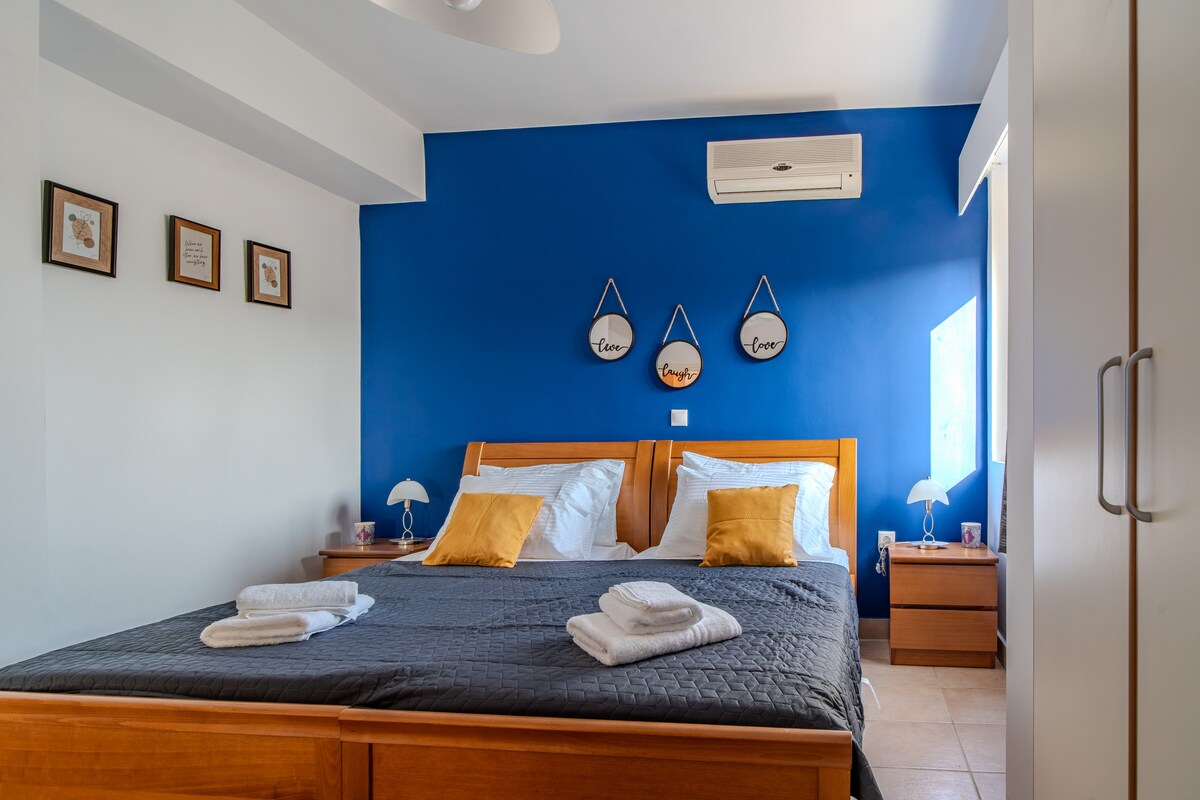 Chumba cha kulala chenye starehe ambapo bluu mkali hukutana na vipengele vya dhahabu, na kuunda mazingira ya joto na ya kuvutia. Maelezo ya kina, mashuka laini na mwanga wa asili huweka mandhari ya usiku wa kupumzika na asubuhi ya amani.