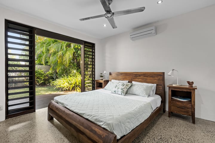 מיטת קינג סייז עם גישה פרטית לדק הקדמי ולחצר.