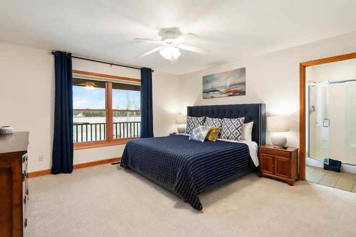 חדר שינה ראשי - מצויד במיטת קינג סייז, חדר רחצה צמוד וטלוויזיה 65 אינץ'.