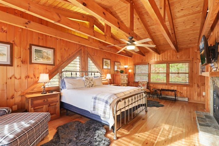 Wake up surrounded by natural wood and morning mountain light. This inviting bedroom offers plush bedding, peaceful forest views, and the cozy feeling of a true cabin retreat.