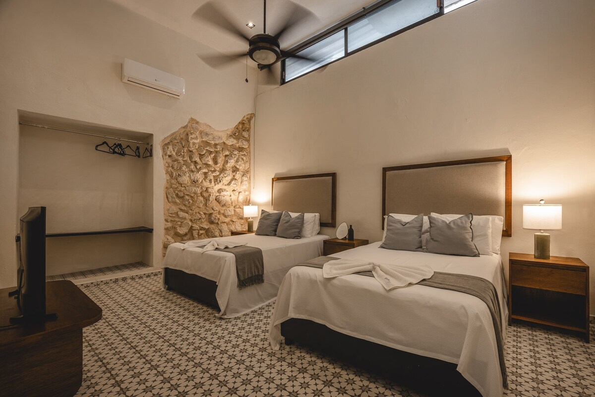 غرفة نوم مريحة بسريرين مزدوجين وجدران أصلية. مساحة مريحة ودافئة، مثالية للاسترخاء كمجموعة أو عائلة.
