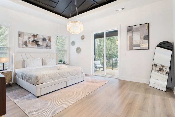 Просторен главен апартман со брачен кревет (широк 180-220 см), лустер и пристап до приватен балкон со поглед кон дворот. Дизајнирано за удобност и стил со огледало во полна големина, модерен декор и многу природна светлина.