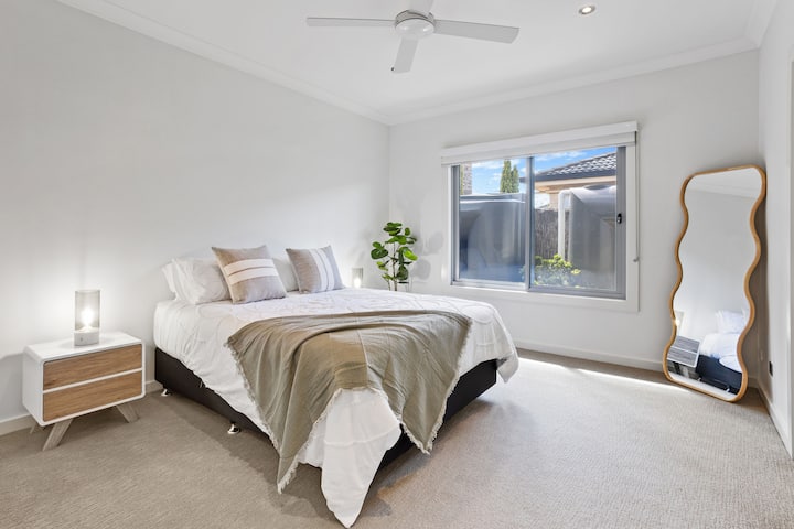 Queen bed, built-in robes, and soft natural tones make Bedroom 4 a restful retreat.