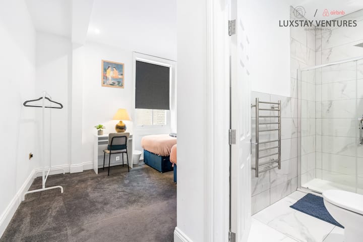 Gezellige slaapkamer met twee eenpersoonsbedden, werkruimte, zachtgrijs tapijt en moderne accenten