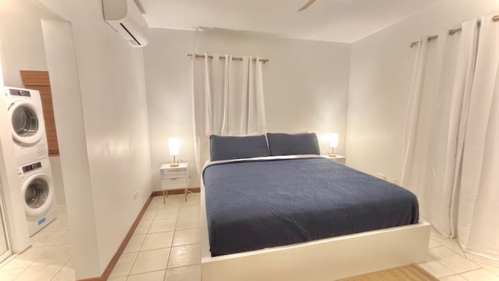 Поглед од влезот на спалната соба каде што се гледаат машината за перење и машината за сушење.