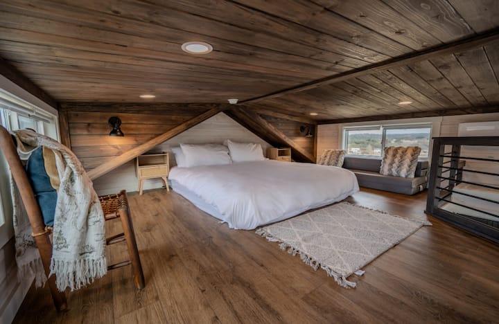 Escape to the cozy loft, accessed by a charming, space-saving staircase. Please note that the ceiling is 3 feet low.