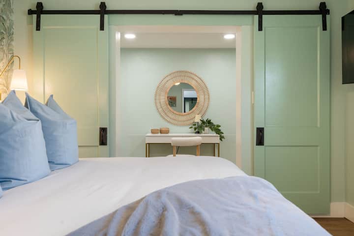 Primary bedroom with king bed, ensuite bathroom, remote working desk, and smart TV