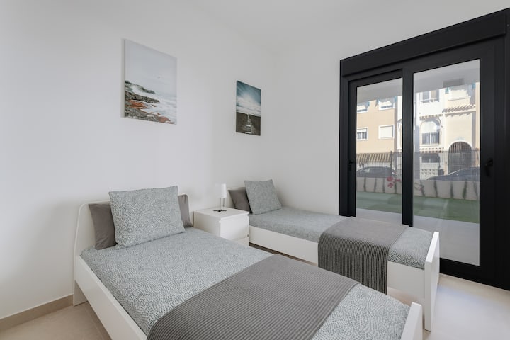 Camera da letto moderna e luminosa con due comodi letti, perfetta per famiglie, bambini o amici. L'accesso diretto alla terrazza aggiunge ulteriore comfort al tuo soggiorno.