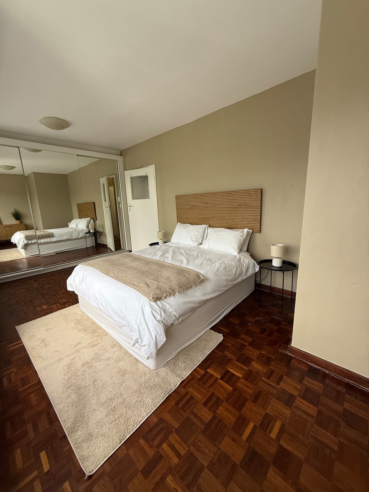 Svetlá hlavná spálňa s mäkkou posteľnou bielizňou, výhľadom na hory a dostatočným priestorom v skrini