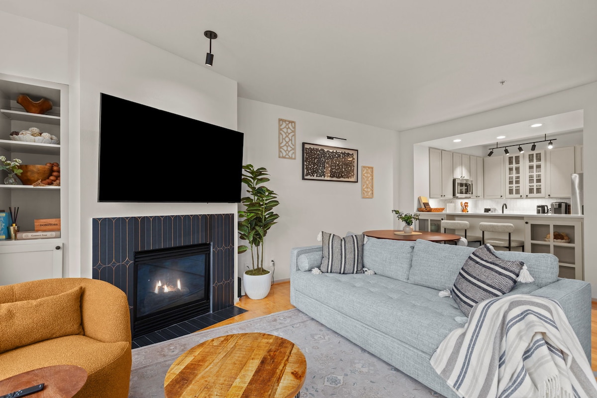 Televizor inteligjent 65 inç në dhomën e ndenjjes. Libra dhe lojëra në dollapin ngjitur me të. 