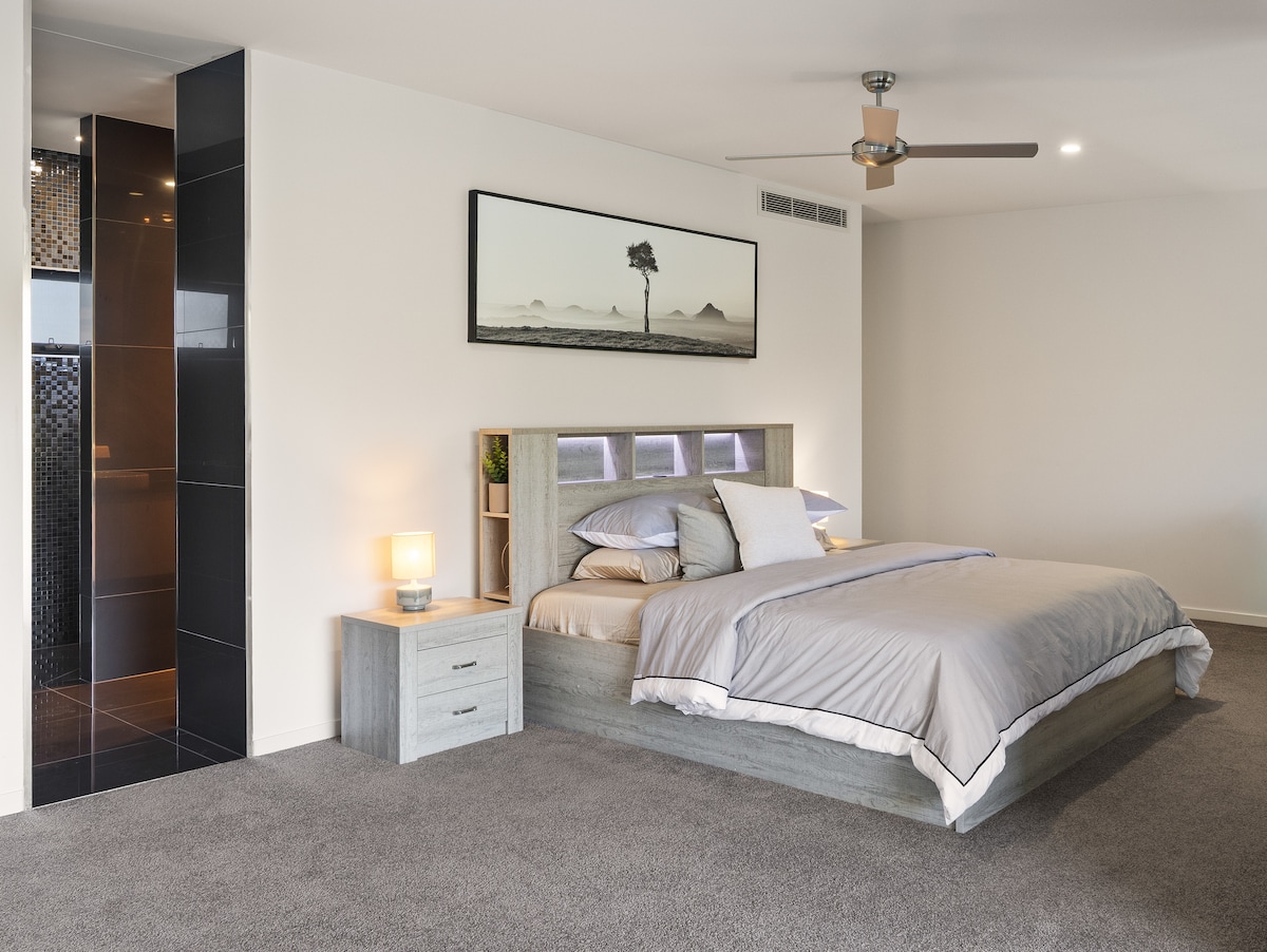 Veľká manželská posteľ v hlavnej spálni na treťom poschodí vám zaručí dobrý spánok. Stenu zdobia ohromujúce fotografie hôr Glasshouse.