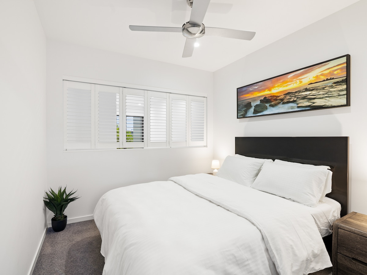 Spálňa 2 je plne vybavená hosťovská spálňa s manželskou posteľou a úžasnou fotografiou pláže Mooloolaba Beach. Okenice poskytujú možnosť svetla a prúdenia vzduchu alebo úplného súkromia.