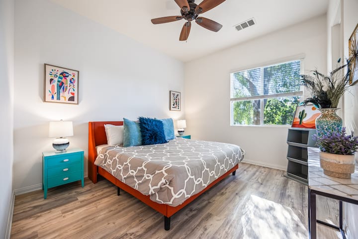Dormitorio 4: un dormitorio luminoso y moderno con atrevidos toques de color, con detalles turquesas y vibrantes obras de arte