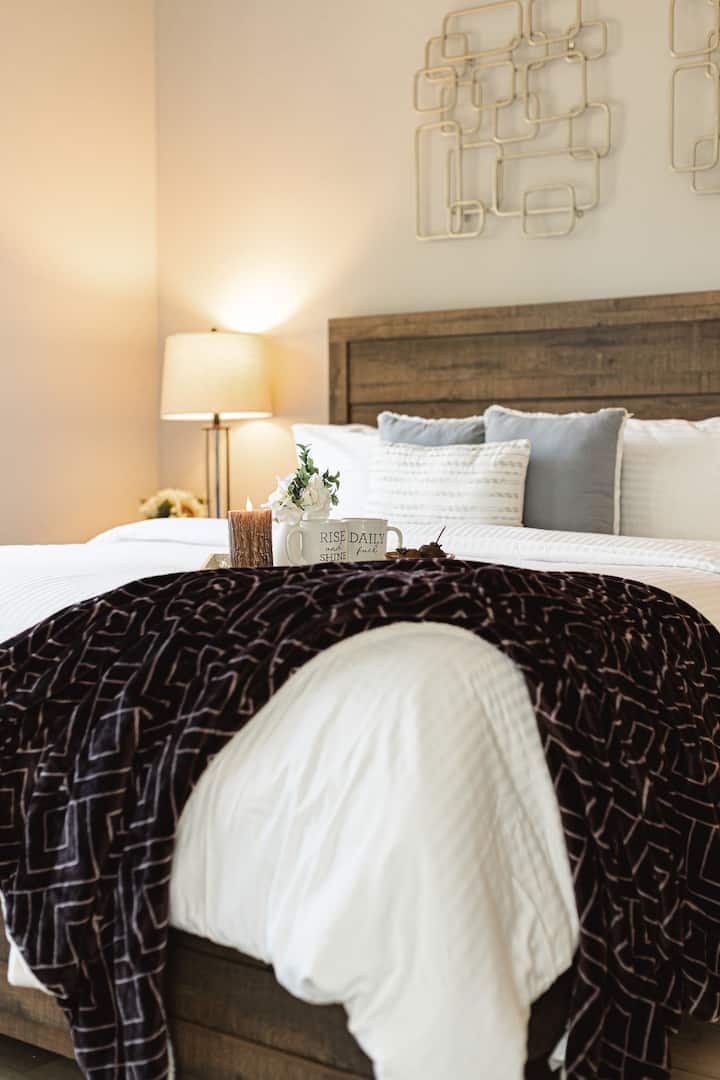 El dormitorio principal ofrece una lujosa cama tamaño king, texturas acogedoras y tonos relajantes para noches de descanso.