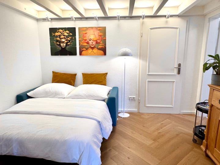Une fois déplié et préparé avec soin, le canapé-lit (1,40 × 2,00 m) devient un endroit confortable pour dormir. Le surmatelas de haute qualité offre un confort supplémentaire et rend l'endormissement particulièrement agréable.