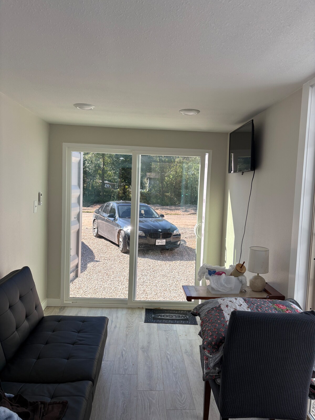 Studio e bukur e pastër me derë rrëshqitëse 60 x 80 dhe dritare të madhe Pella. Pamja nga dyert është një kombinim i rrugicës dhe pemëve të gjelbra që duken kaq të qeta. 