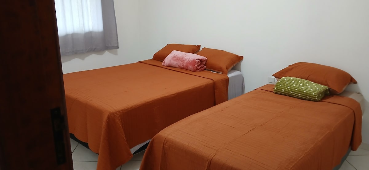 Priestranná spálňa s 1 manželskou posteľou a 1 samostatnou posteľou, so stropným ventilátorom. 