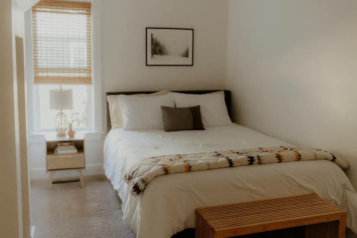 ห้องพักขนาดควีนไซส์ที่สะดวกสบายนี้อยู่ที่ชั้น 1 และมีโต๊ะข้างเตียง เก้าอี้ผีเสื้อหนัง และตู้เสื้อผ้าเล็ก ๆ ห้องน้ำเต็มรูปแบบตรงข้ามห้องโถง