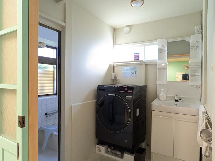 洗面所と浴室。ドラム式の洗濯乾燥機があります。