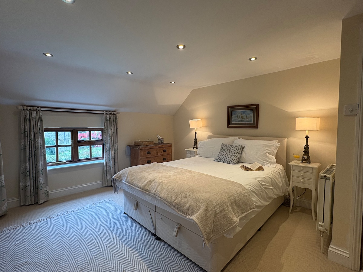 ห้องนอนสไตล์ดับเบิลที่สว่างและกว้างขวาง ออกแบบมาเพื่อการนอนหลับพักผ่อนเต็มอิ่มในยามค่ำคืน มีเตียงที่สบาย ผ้าปูที่นอนนุ่ม และมีพื้นที่มากมายให้ผ่อนคลาย ที่พักที่สงบนี้เหมาะสำหรับการพักผ่อนหลังจากใช้เวลาทั้งวันในชนบท”