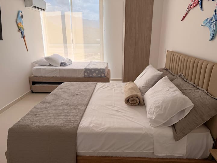 LA habitacion es amplia y tiene una Cama Queen y Una cama sencilla con nido.