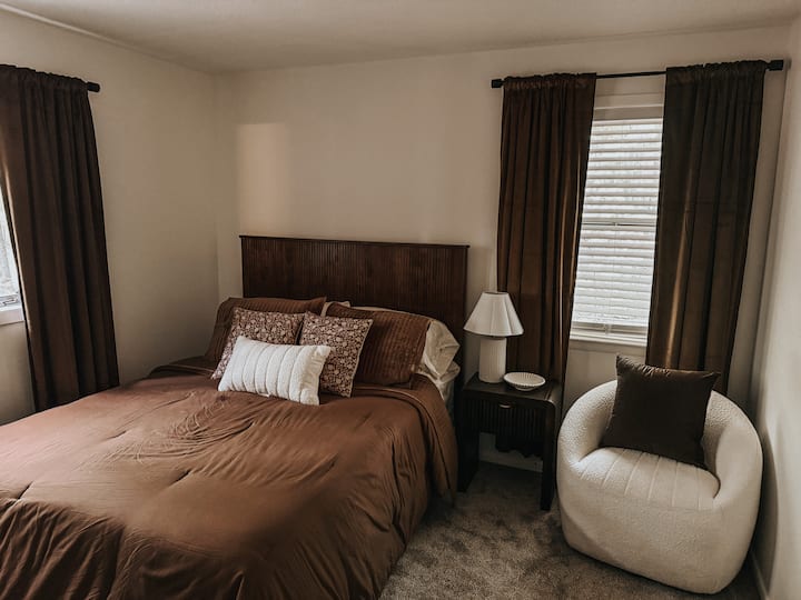 Lákavá spálňa pre hostí s mäkkou posteľou a útulným sedadlom – ideálna na relaxačné pobyty a rodinné výlety.