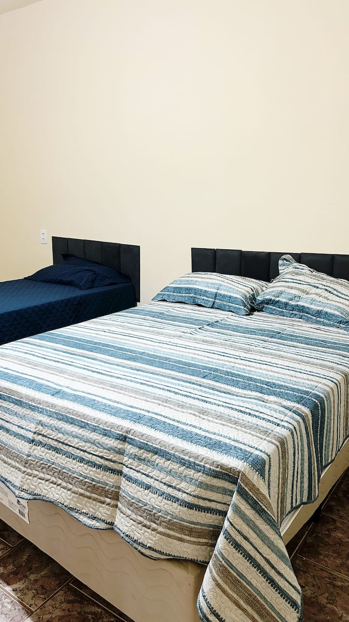 ოთახი 01 — მყუდრო და კარგად ვენტილირებადი, აქ არის ერთი და ორიადგილიანი საწოლი, რაც იდეალურია ოჯახებისა თუ მცირე ჯგუფებისთვის. აქ არის კომოდი ტანსაცმლის მოსაწესრიგებლად და ჭერის ვენტილატორი, რომელიც ყველაზე ცხელ დღეებსაც კი კომფორტულს გახდის.