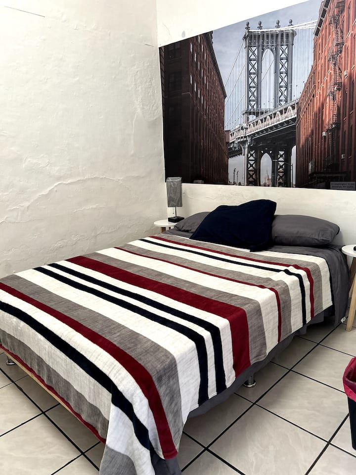 חדר עם מיטה זוגית, טלוויזיה וארון, חדר רחצה מחוץ לחדר.