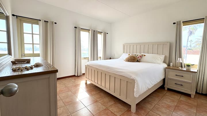 تحتوي إحدى غرفتي النوم في الطابق العلوي، على سرير بحجم كينج، وخزانة ملابس، وأبواب تفتح على شرفة مجاورة.