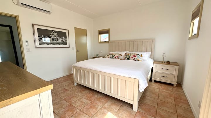 تحتوي إحدى غرفتي النوم في الطابق العلوي، على سرير بحجم كينج، وخزانة ملابس، وأبواب تفتح على شرفة مجاورة.