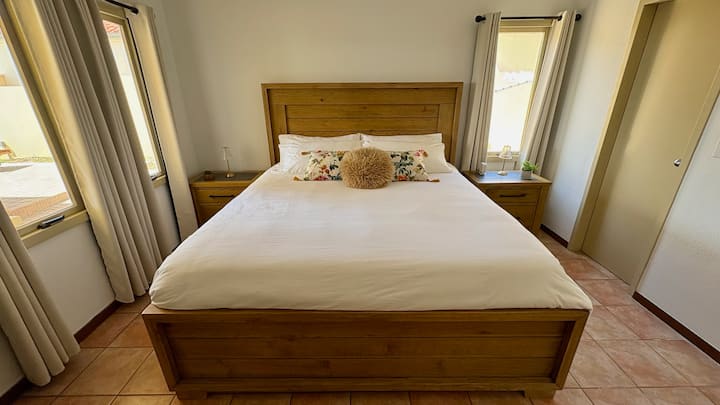 على المستوى الرئيسي، تقع غرفة النوم الرئيسية قبالة غرفة المعيشة مباشرة، مما يوفر انتقالًا سلسًا من مساحة المعيشة الرئيسية إلى ملاذ خاص.