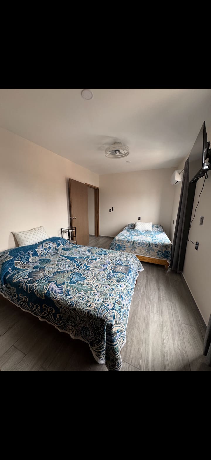 سريران بحجم كوين مع مراوح ثريا ونوافذ وظيفية ومكيف هواء/تدفئة منفصلة صغيرة وتلفزيون.