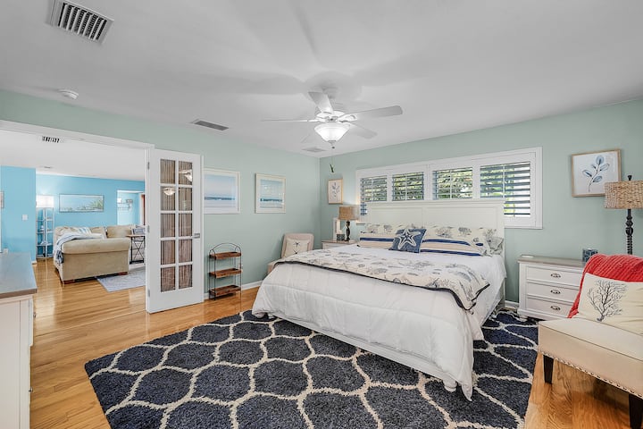 ห้องสวีทหลักเปิดไปยังพื้นที่นั่งเล่นผ่านประตูฝรั่งเศส ผสมผสานความสะดวกสบาย แสงสว่าง และการไหลเวียนที่ง่ายดายสำหรับการพักผ่อนในเคปคอรัลของคุณ