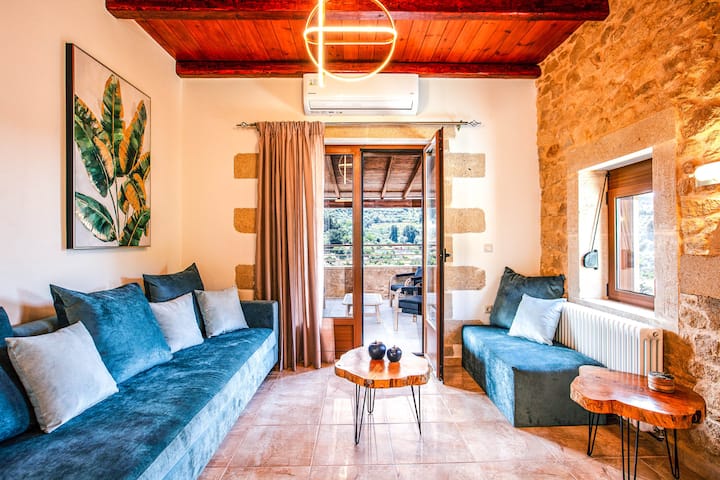 Ghorofa ya Chini: Sebule yenye starehe iliyo na meko na sofa inayoweza kumtoshea mgeni wa ziada