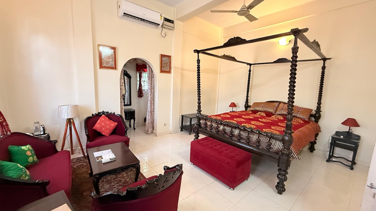 Луксозна стая с нежни цветове и класическо обзавеждане, напомнящо за благородните домове на Асам. Това е една от нашите първокласни стаи с голямо двойно легло с изящна дървена резба, съчетаваща комфорт с елегантност.

