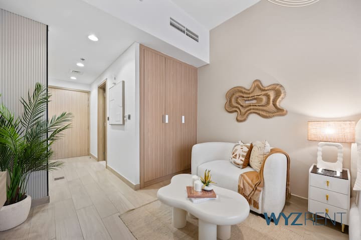 Un couloir élégant mène à un espace de vie confortable avec de l'art moderne et un éclairage doux.