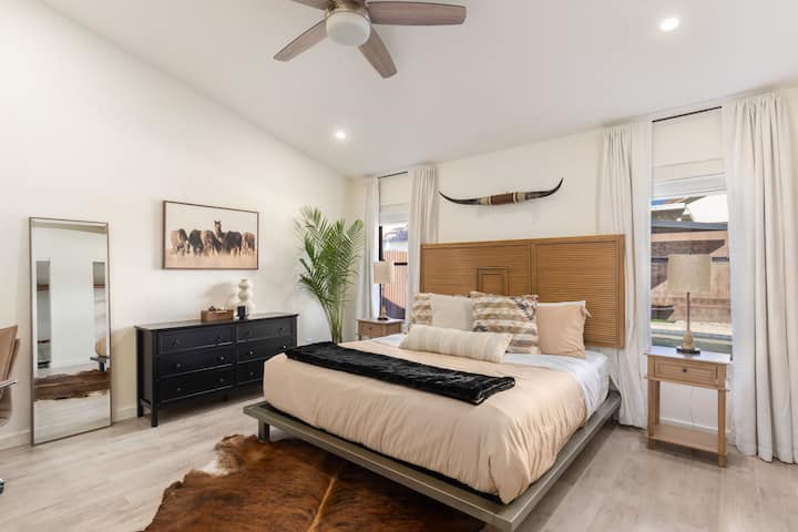 Priestranná izba, pohodlná manželská posteľ s tmavými žalúziami a závesmi. 