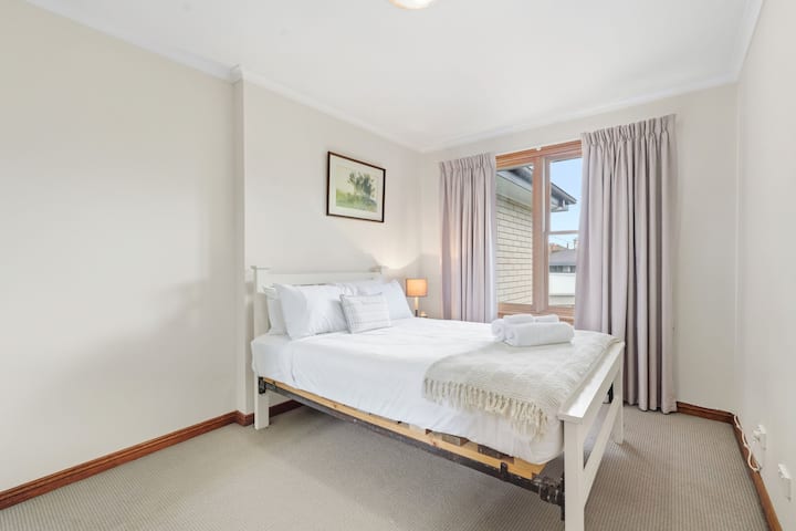 غرفة نوم ساحرة: يتدفق ضوء الشمس، ويدعو إلى الاسترخاء مع الفراش الرقيق والديكور الهادئ.