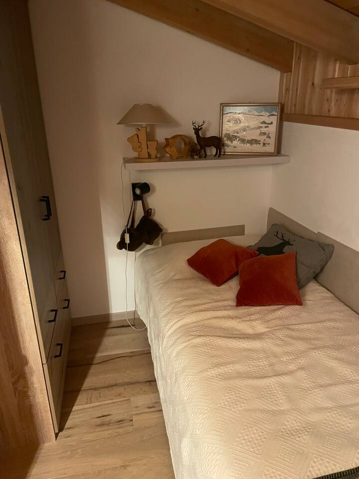 Una de las dos camas individuales en el dormitorio pequeño. Amplio armario directamente en la habitación.