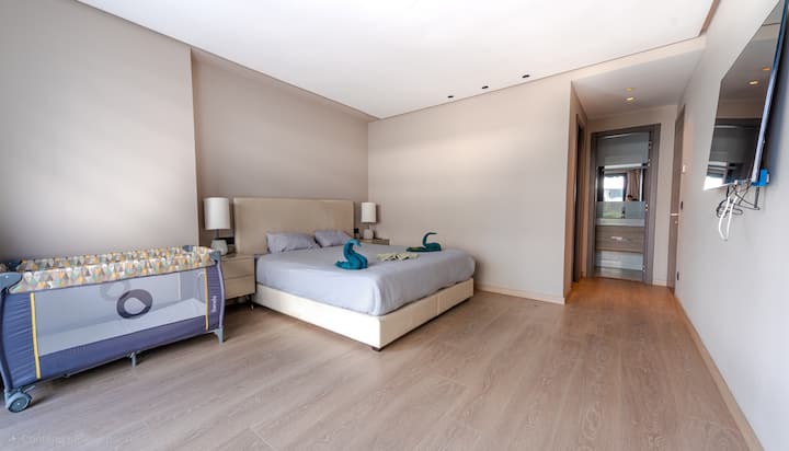 Amplio dormitorio principal con cama tamaño king, balcón privado, vestidor, televisor inteligente y baño privado para una comodidad de alta gama y una privacidad total.

