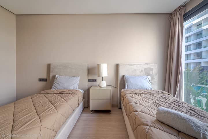 Habitación luminosa con dos camas individuales, Smart TV y un gran armario, ideal para recibir a familiares o amigos en un confort moderno.