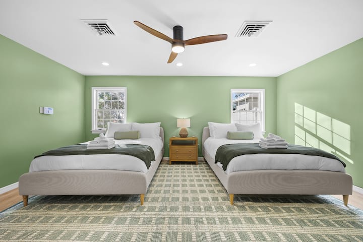 Svetlá a útulná spoločná izba s dvoma pohodlnými manželskými posteľami Queen, mäkkým šalviovým dekorom a moderným stropným ventilátorom. Užite si pohodlnú posteľnú bielizeň a centrálnu klimatizáciu pre chladný a pokojný spánok. Ideálne pre rodiny alebo skupiny.