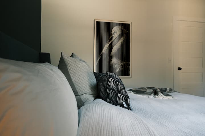 Lit King Size dans la chambre en bas avec couette et beaucoup d'oreillers pour votre confort.