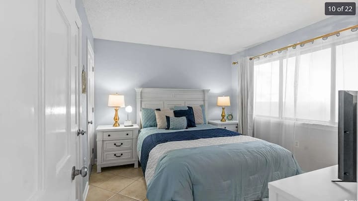 Prostrana spavaća soba s udobnim krevetom, ormarom i televizorom.