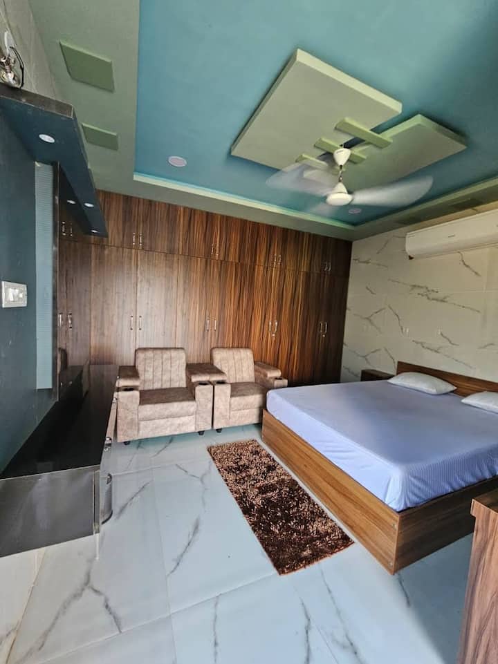 Целосно опремена спална соба во Тирупати со удобен брачен кревет, премиум душек, гардеробер, клима уред, работна маса, бања и сите основни удобности. Дизајнирано за удобно, удобно и луксузно доживување за престој.