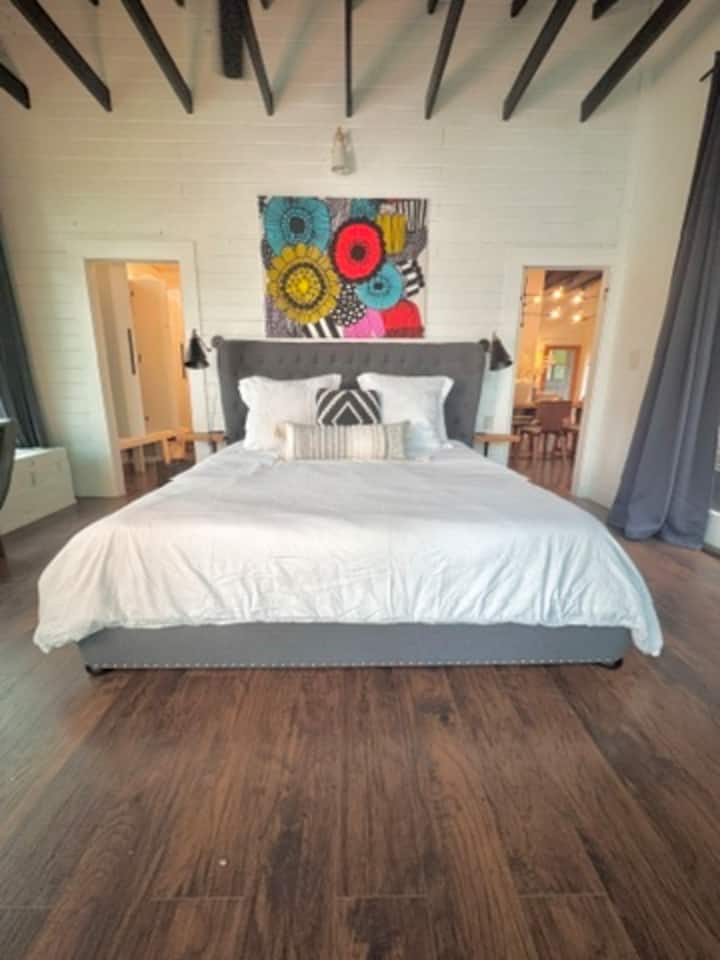 Prebuďte sa s pokojným výhľadom na jazero v tejto elegantnej hlavnej suite s pohodlnou posteľou veľkosti king a farebnými dizajnérskymi umeleckými dielami.