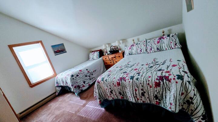 تحتوي غرفة النوم على سرير مزدوج طويل للغاية وسرير بحجم كبير.