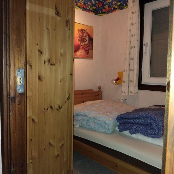 Mala spavaća soba s krevetom 80 x 200 cm s dječjim svjetiljkama i prozorom koji se može zaključati. Ormar je privatni, ali ima dovoljno prostora za pohranu u drugim spavaćim sobama.