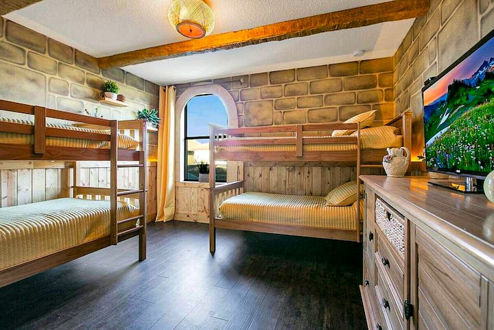 ✨ Honeylight Suite: A bright and happy retreat featuring two sets of twin bunk beds and warm, golden castle-themed décor.